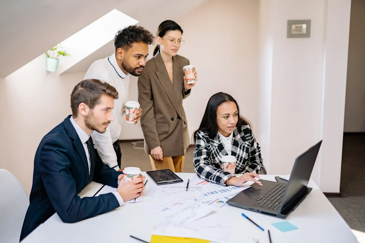 Group of professionals collaborating around a laptop